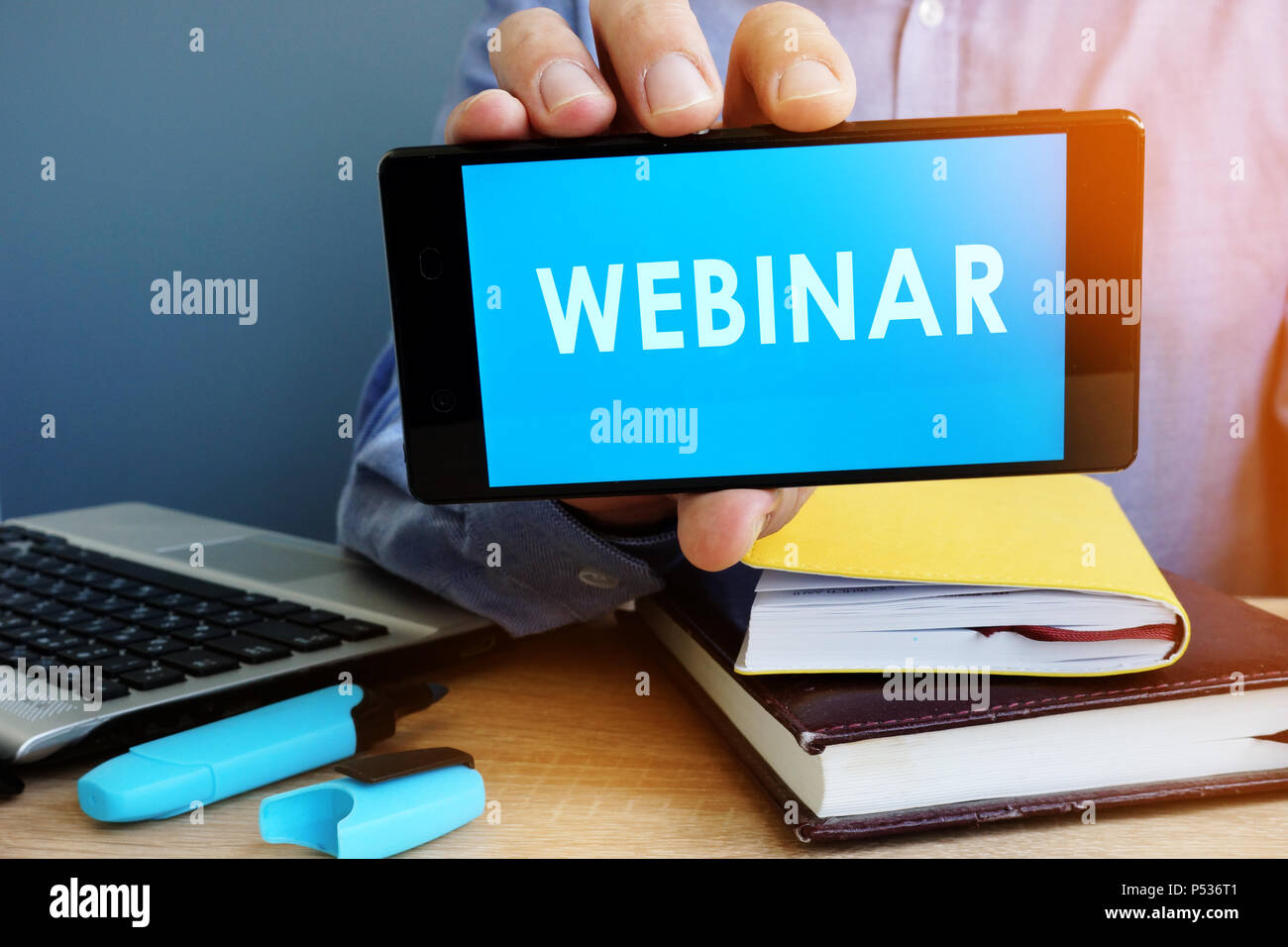 Man holding smartphone with word webinar. Stock Photo