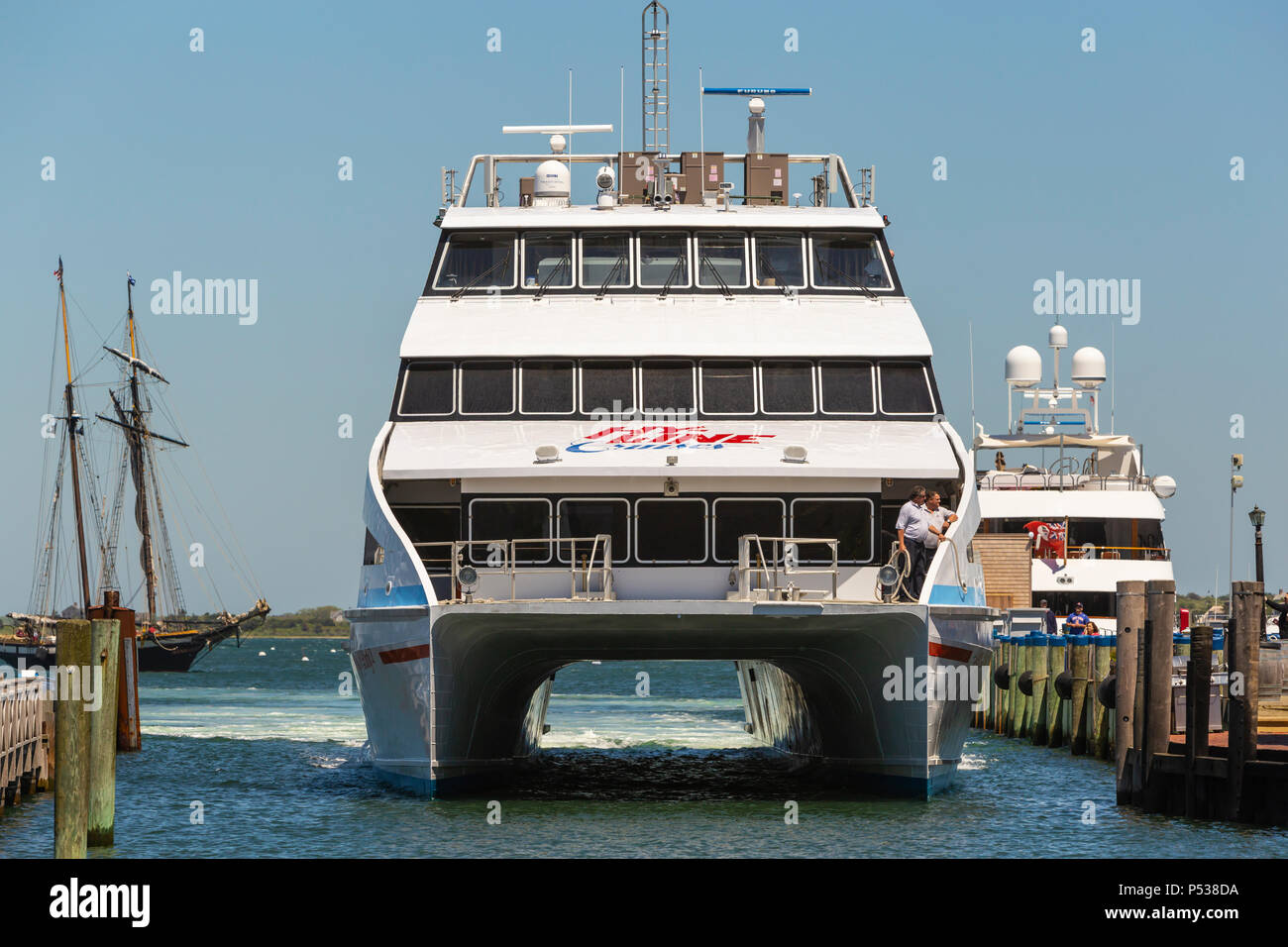 A Hy-Line Cruises high-speed catamaran ferry prepares to dock at Straight Wharf in Nantucket, Massachusetts. Stock Photo