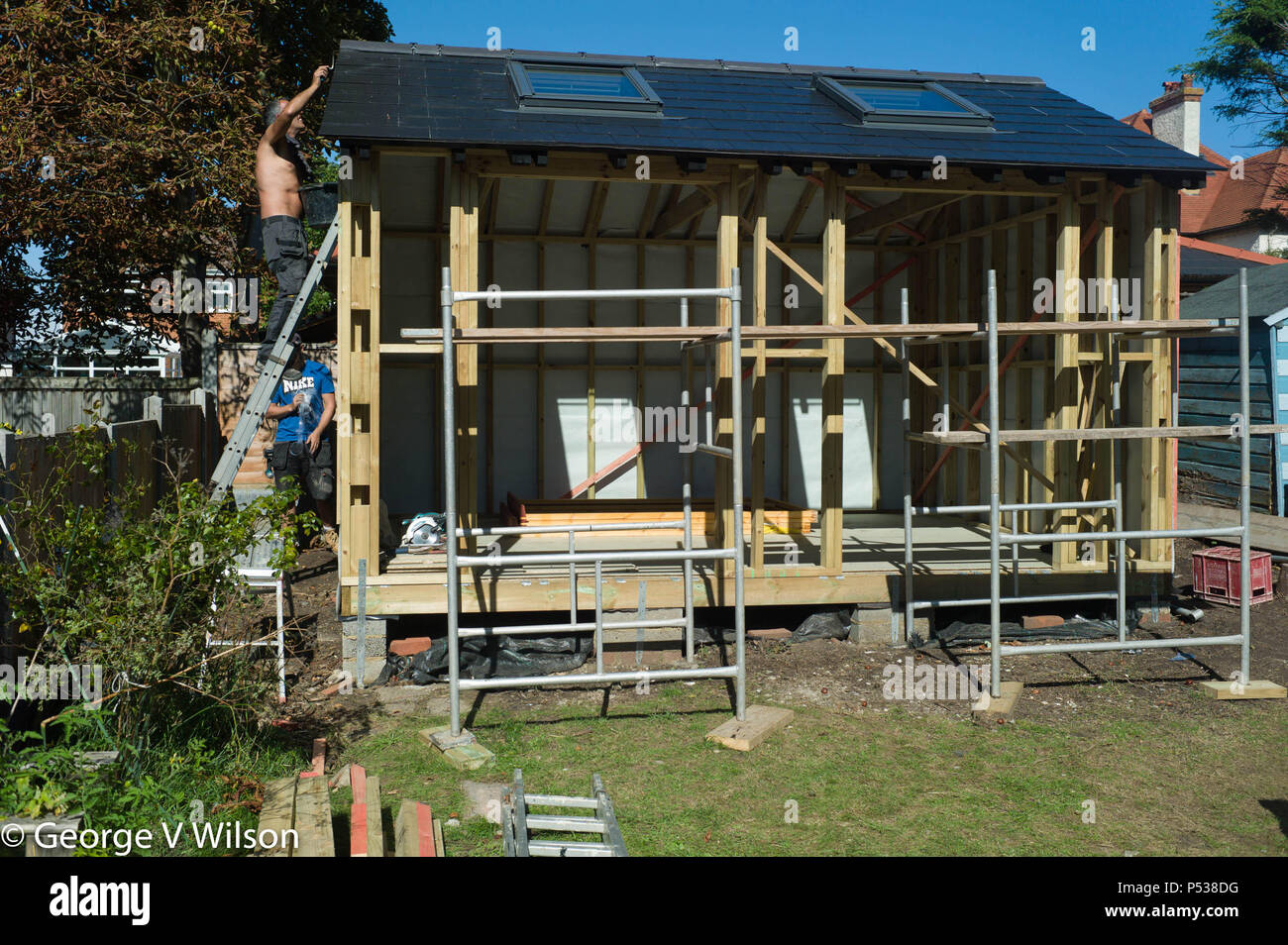 Builders Constructing A Large Shed In A Garden Stock Photo