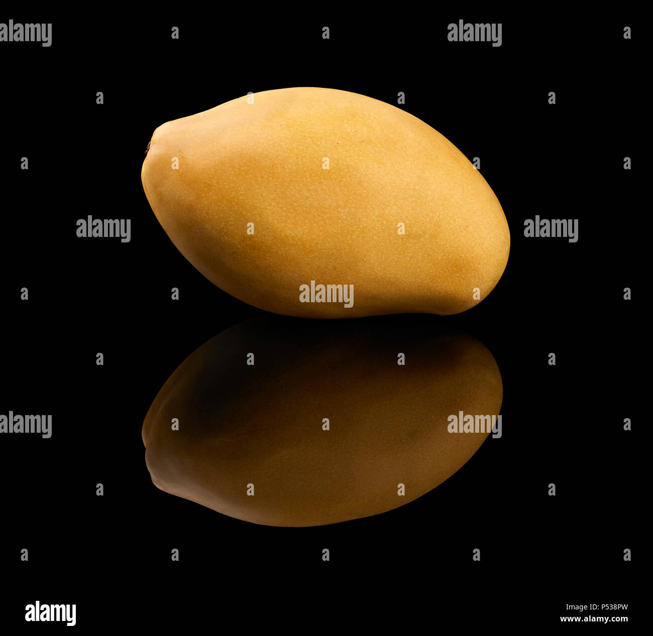 One yellow mango fruit isolated on black reflective background Stock Photo