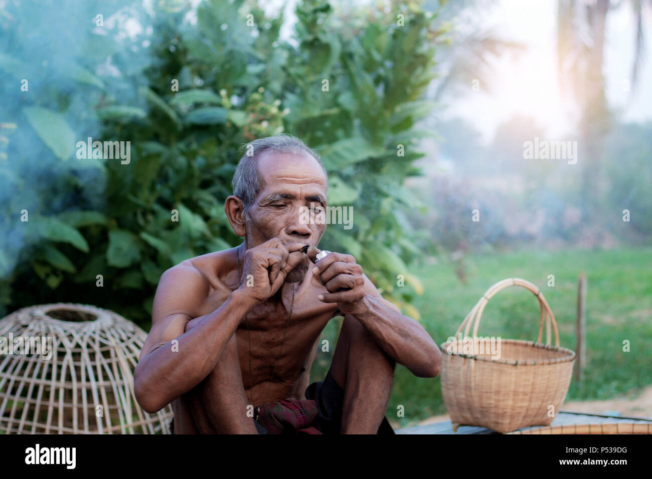 Old men are smoking and basket in countryside. Stock Photo