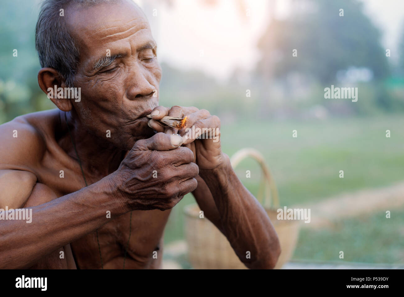Old men in rural areas are smoking cigarettes. Stock Photo