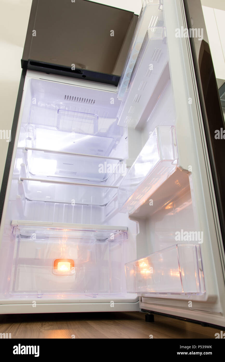 A open fridge in the kitchen. Empty clean refrigerator. Stock Photo