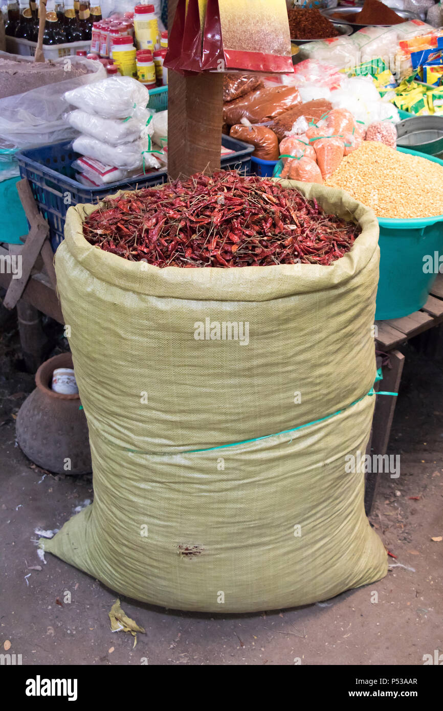 Dried red peppers in large sack on the market. Offer of paprika in the