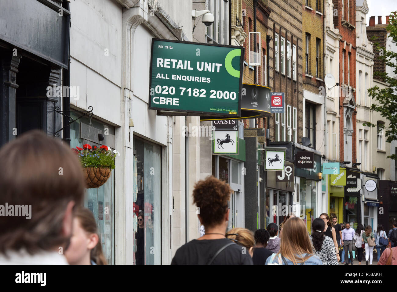A retail unit estate agent's to let sign on a closed shop on Upper Street, Islington, North London, where shops are closing as the high street goes in Stock Photo