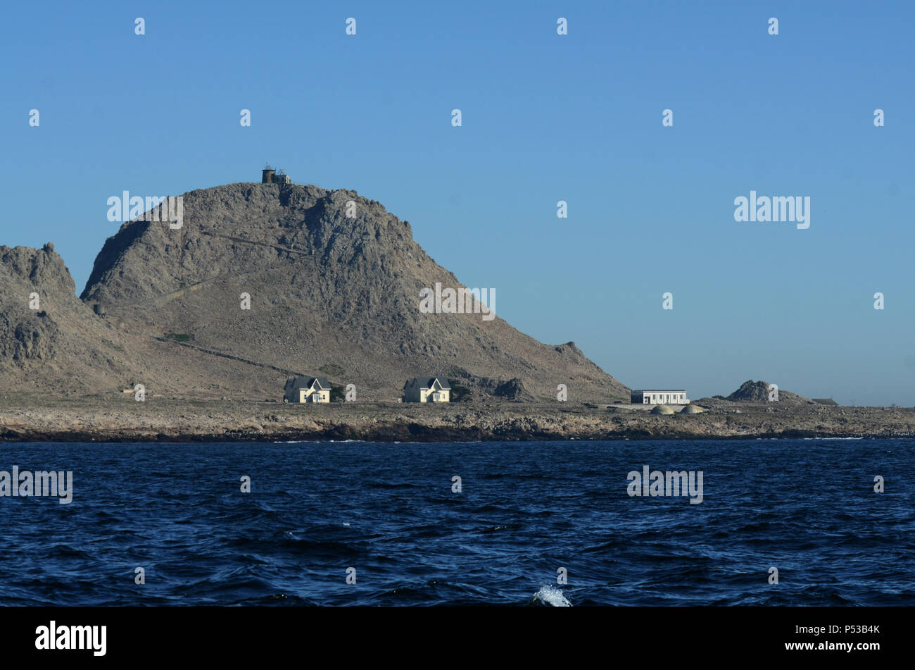 View of the Southeast Farallon Island, with  houses where scientific researchers live, as well as another building, and the Lighthouse on Tower Hill Stock Photo