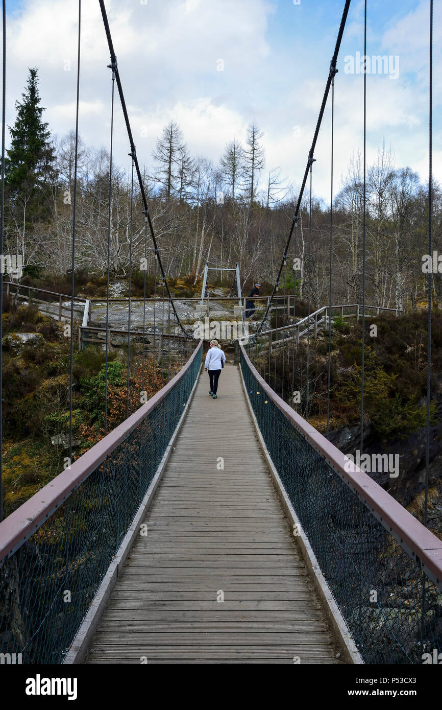 Suspension bridge across the Black Water river at Rogie Falls in Ross-shire in the Highlands of Scotland Stock Photo
