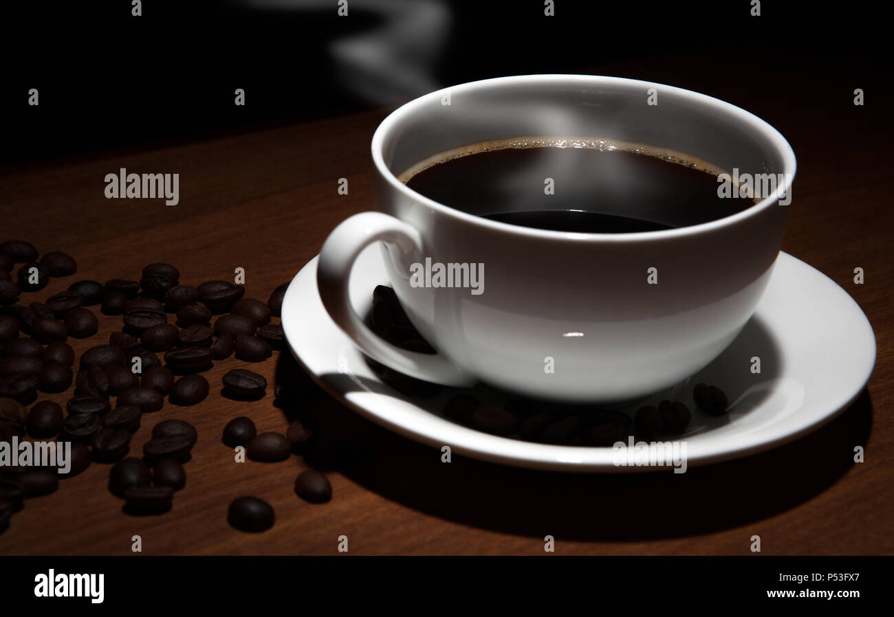 cup of coffee and beans on the wooden table on a black background Stock ...