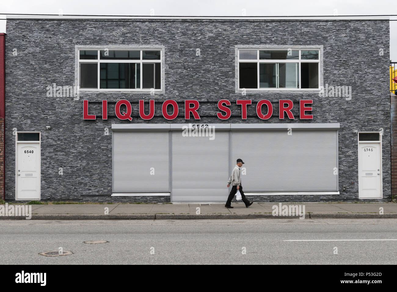The large red letters spelling Liquor Store, on a grey stoned building