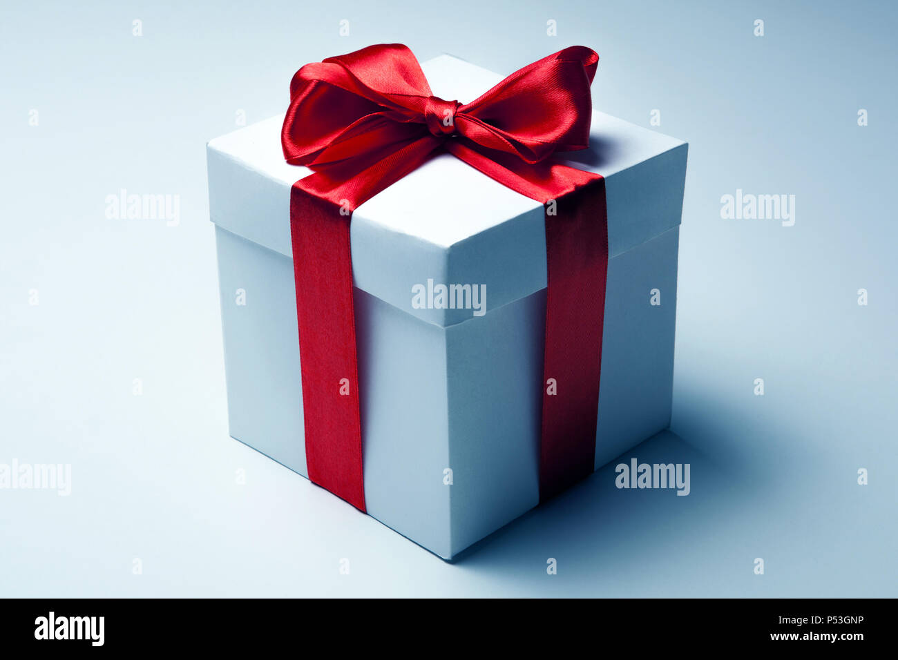 White gift box with red ribbon on white background Stock Photo - Alamy