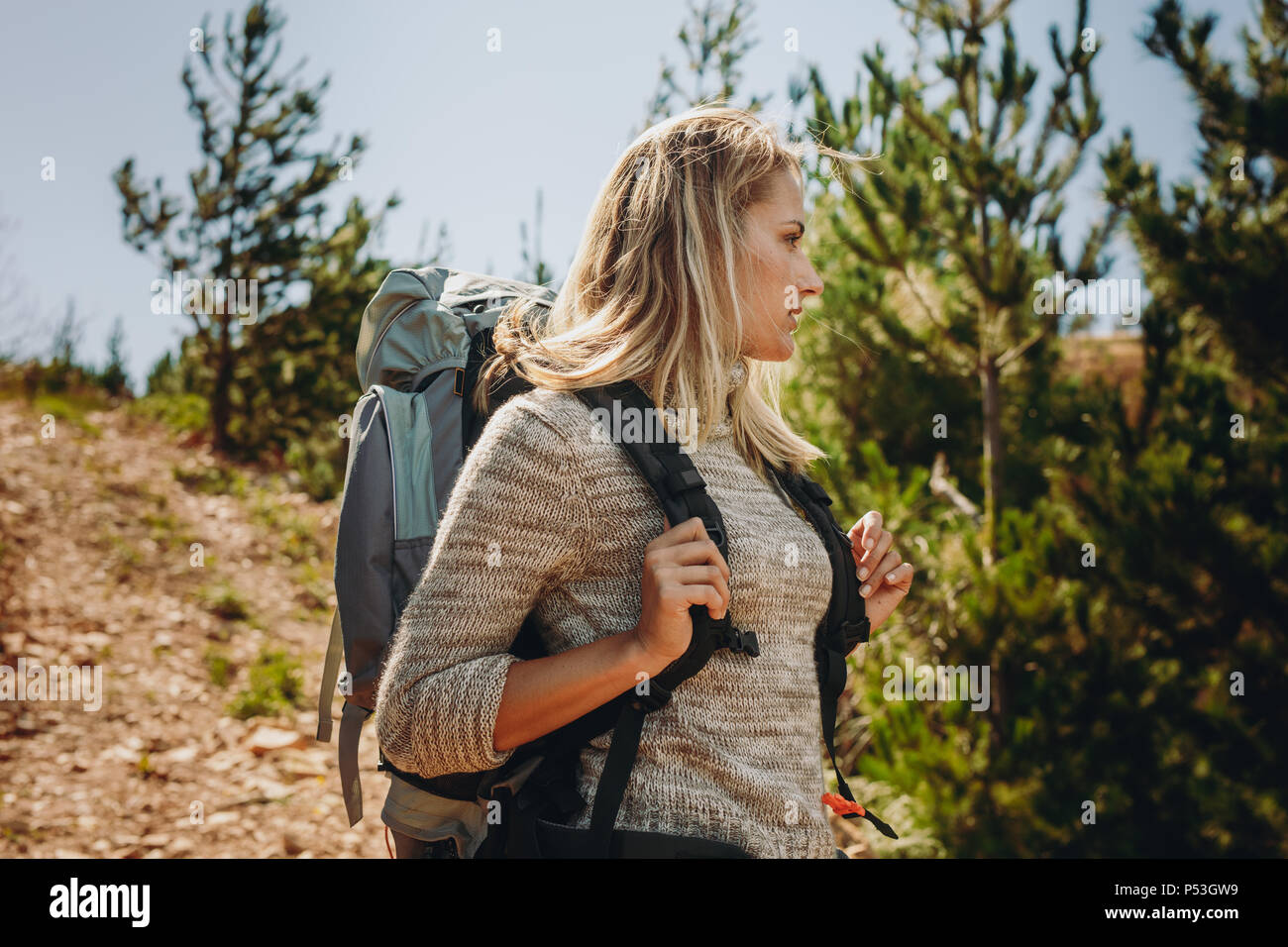 Woman hiker trekking on mountain. Woman exploring nature walking through mountain trail. Stock Photo