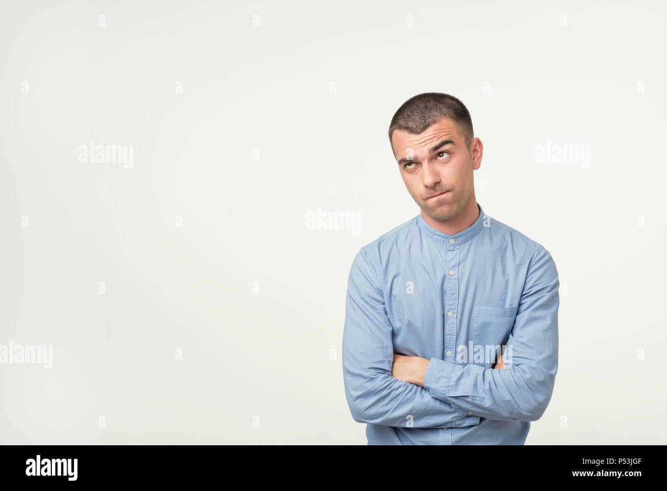 Let me think or oubt concept. Young hispanic man is very serious and pensive, trying to solve problems in job Stock Photo