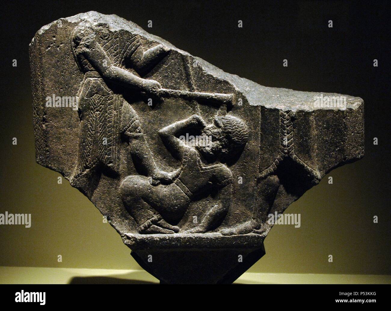 ARTE MESOPOTAMICO. PERIODO PALEOASIRIO (2150 a. C. -1470 d. C.). Fragmento en basalto de la ESTELA DE LA VICTORIA o ESTELA DE MARDIN. Erigida por Shamshi-Adad I (o Samis-Addu) de Asiria para celebrar una victoria sobre la ciudad de Qabra y el reino de Urbilu en 1880 a. C. gracias a una alianza con el rey Eshnunna. Detalle del REY GOLPEANDO CON SU PICA Y SU HACHA DE COMBATE A UN ENEMIGO CAIDO EN TIERRA. Mesopotamia del Norte. Región de Sinjar. Museo del Louvre. París. Francia. Stock Photo