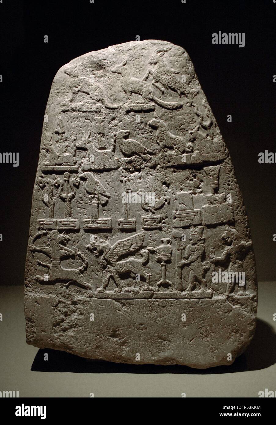 ARTE MESOPOTAMICO. EPOCA CASITA. KUDURRU de la primera mitad del s. XII a. C. Estela en piedra calcárea decorada con relieves de símbolos divinos. En las franjas superiores aparecen ANIMALES Y CRIATURAS FANTASTICOS y en la franja inferior un CENTAURO TIRANDO EL ARCO, DRAGON-LEON, LAMPARA CON SOPORTE (Símbolo de Nusku), HOMBRE-TORO CON ESTANDARTE y un HOMBRE-LEON. Procede de Merkes. Babilonia. Exposición Babilonia. Museo del Louvre. París. Francia. Stock Photo