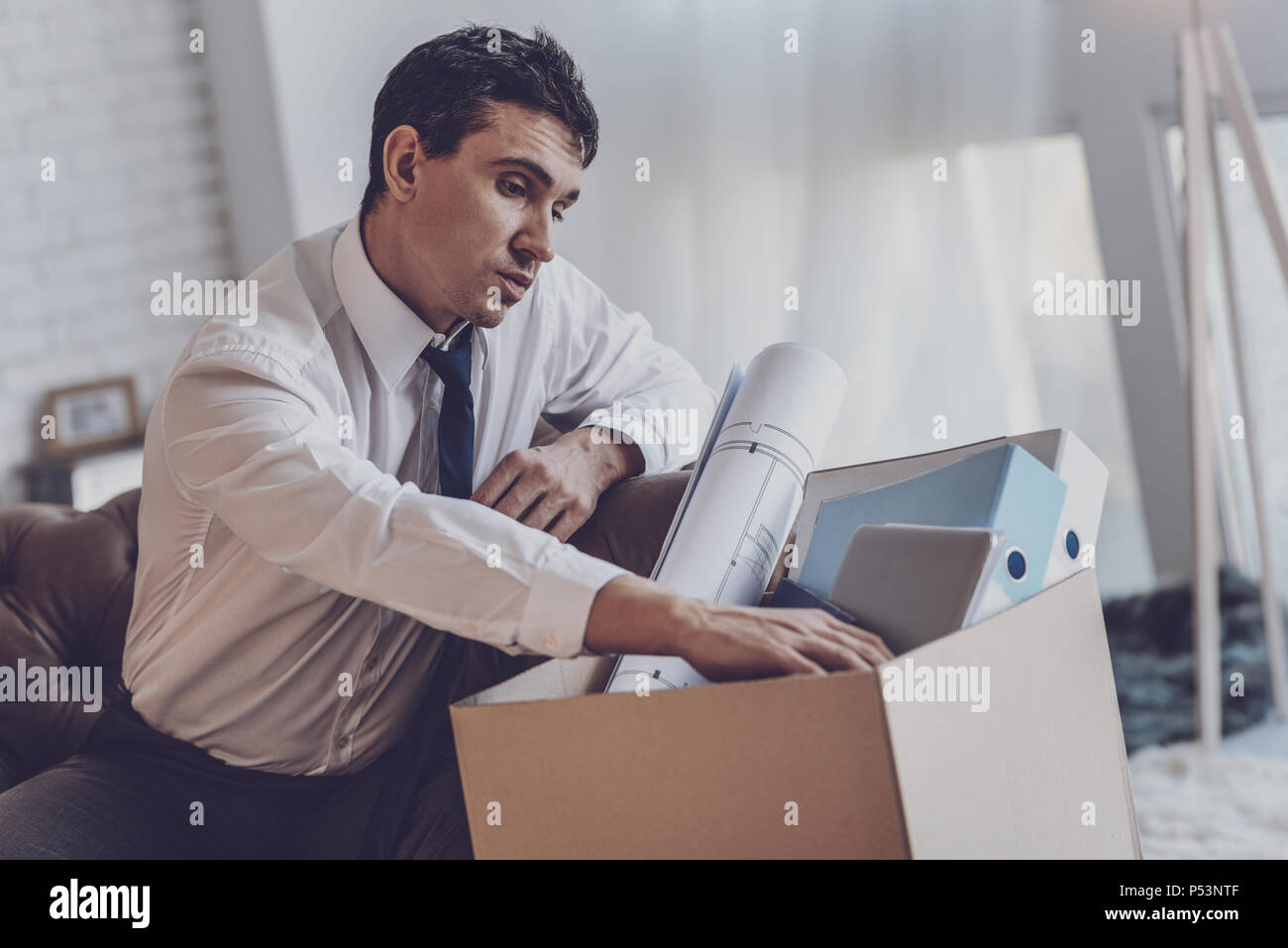 Depressed cheerless man looking into the box Stock Photo