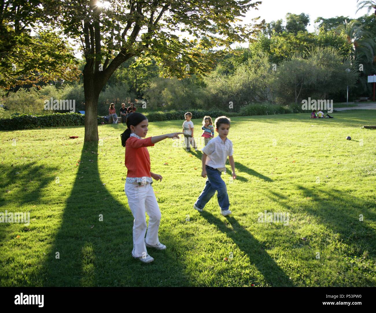 Niña de siete años y niño de seis años jugando en un parque. Stock Photo