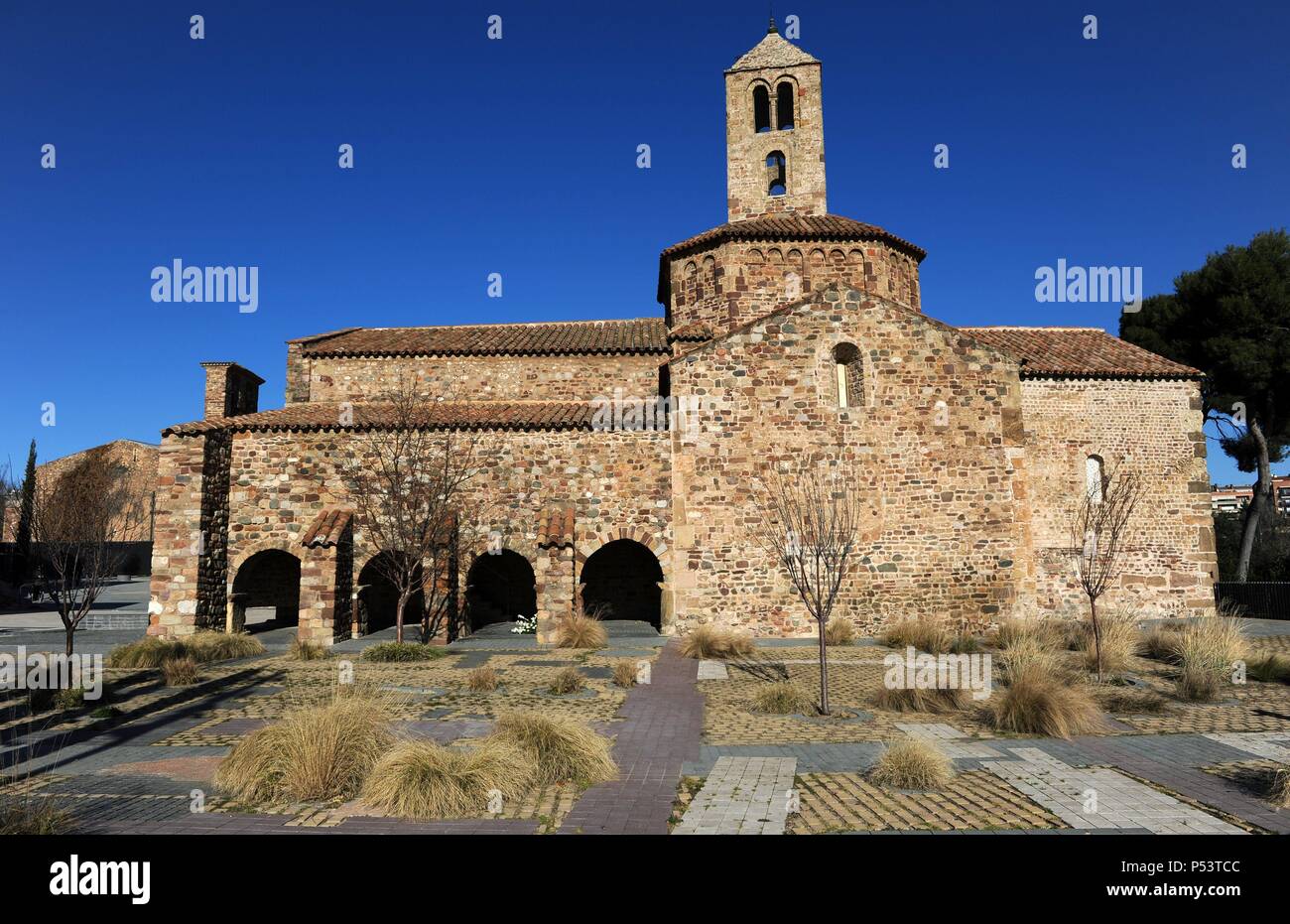 Romanesque art. Spain. 12th century. Church of St. Mary, consecrated in 1130. Exterior view of square apse, the octogonal dome crowned with two-story bell tower and south facade with remains of a portico with four arches, ancient cloister of augustines. Tarrasa. Catalonia. Stock Photo