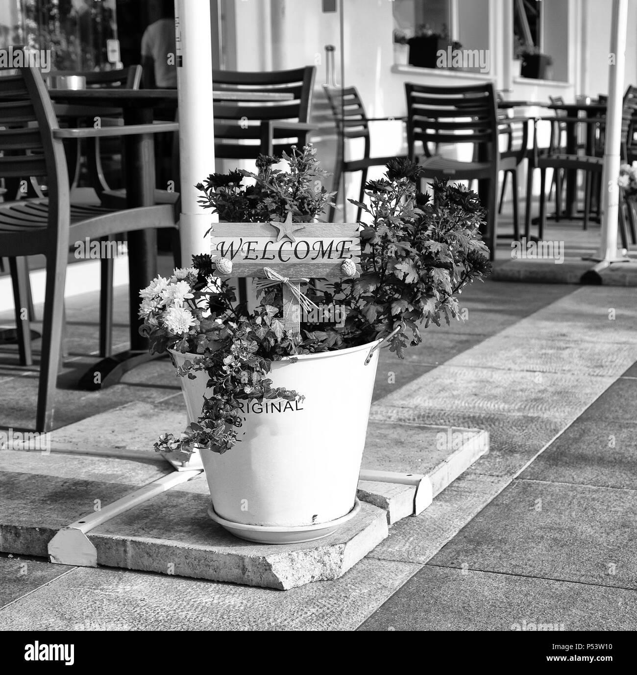 in cyprus outside of restaurant the signal of welcome and the flower near chairs and table concept of inviting Stock Photo