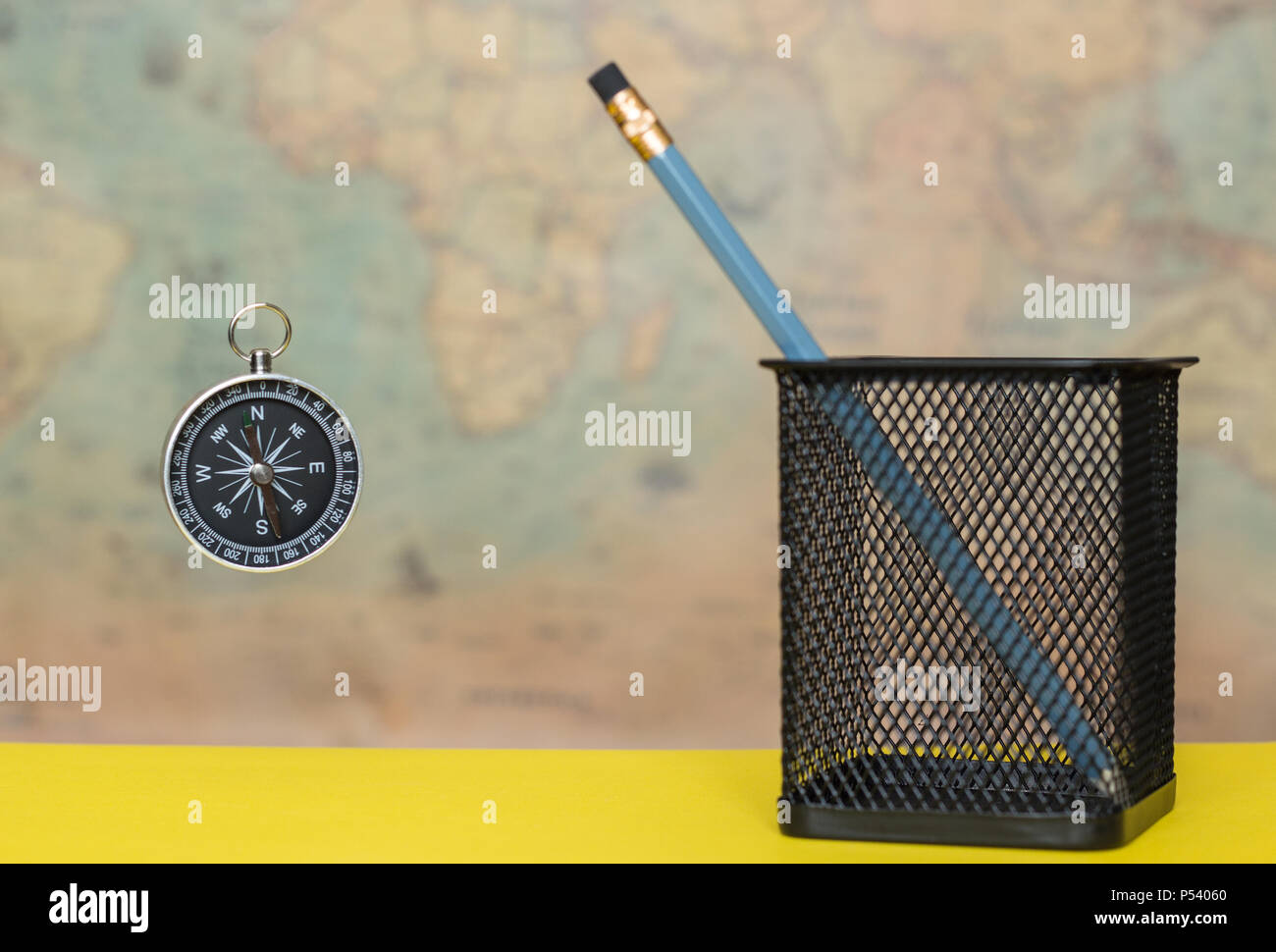Compass Pot Metal Compass and pencil in a metal pot on a blurred background of an old ...