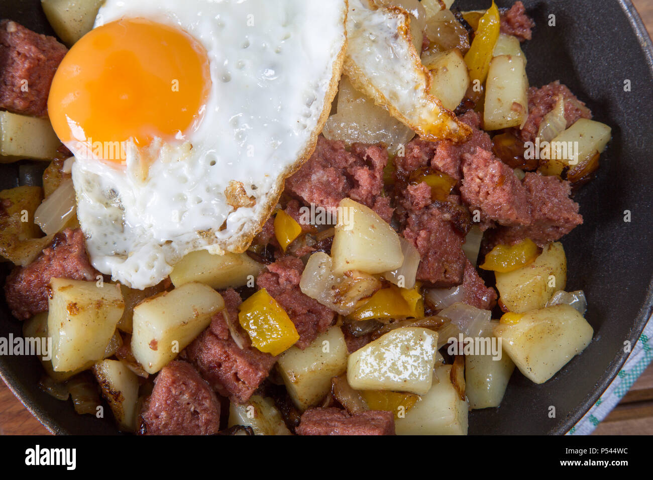 Freshly cooked Corned beef hash with a fried egg served in the pan