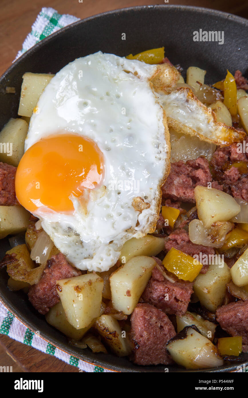 Freshly cooked Corned beef hash with a fried egg served in the pan
