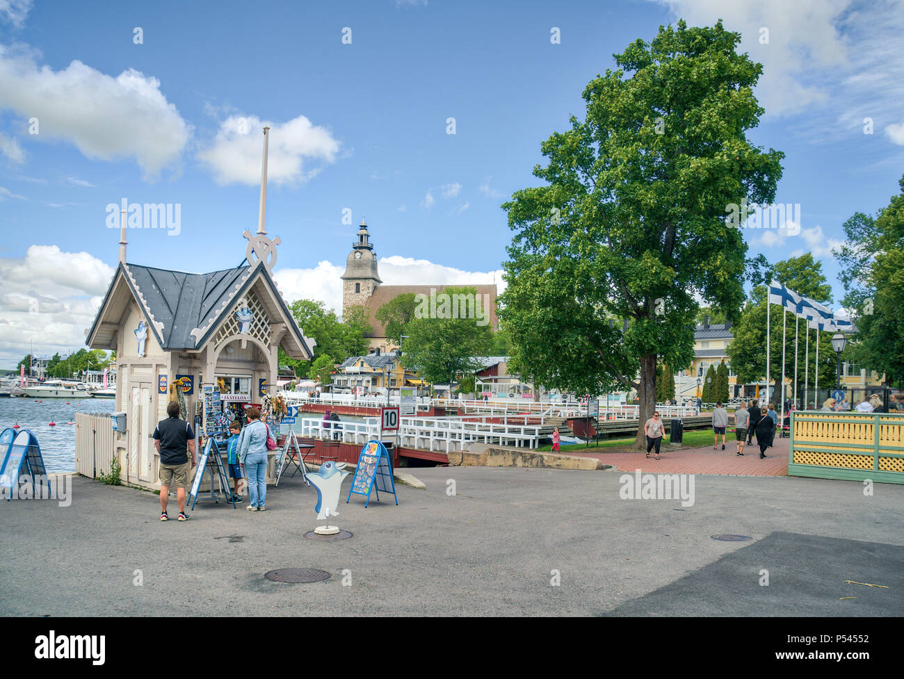 NAANTALI, FINLAND - 23/6/2018: A small souvenier shop with people by with church tower in the background in Naantali harbour Stock Photo