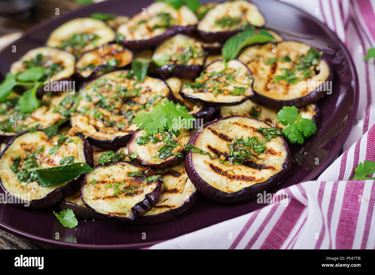 Eggplant grilled with balsamic sauce, garlic, cilantro and mint. Vegan food. Grilled aubergine. Stock Photo