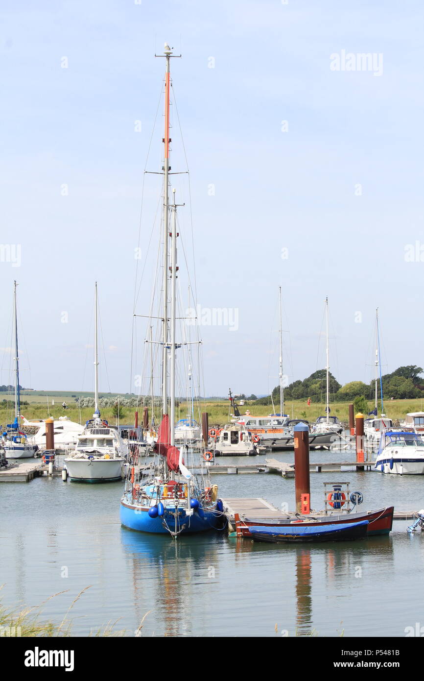 Coastal landscapes - mast of brightly coloured yacht reflected on ...