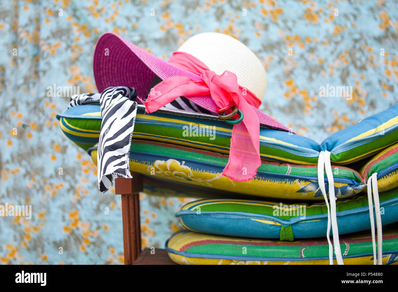 Ladies wide brimmed hats laid on the top of colorful mattresses Stock Photo