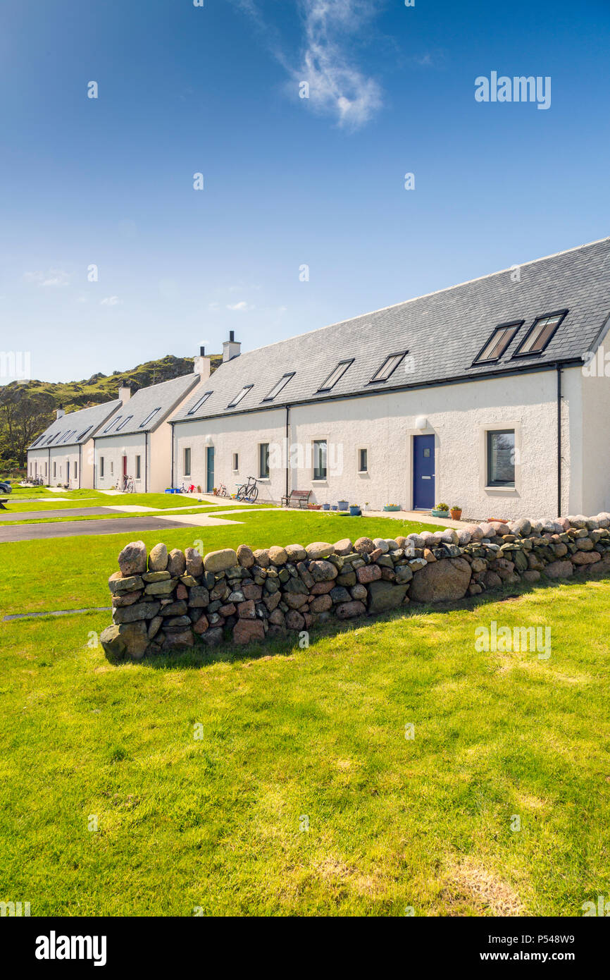A row of newbuild Iona Housing Partnership cottages with colourful