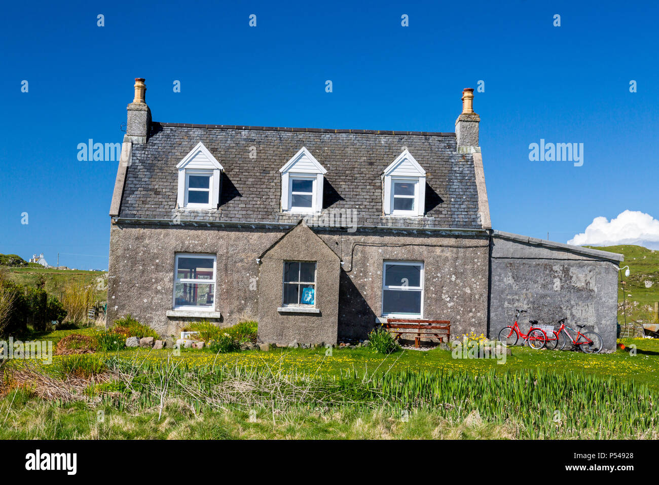 An original small cottage with red bicycles outside on the Hebridean island of Iona, Argyll and Bute, Scotland, UK Stock Photo