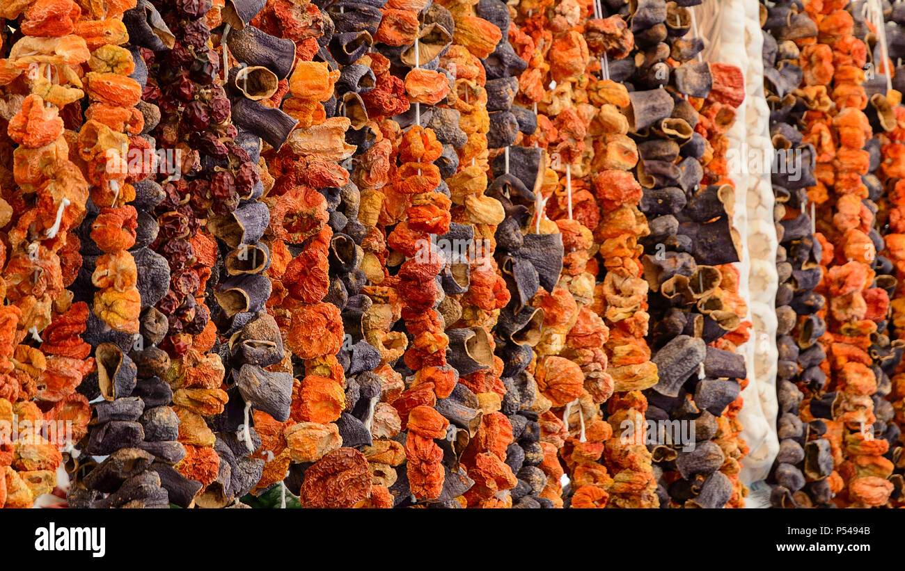 Oriental spices sun dried eggplants paprika peppers and vegetables hanging up at Turkish grocery market Stock Photo