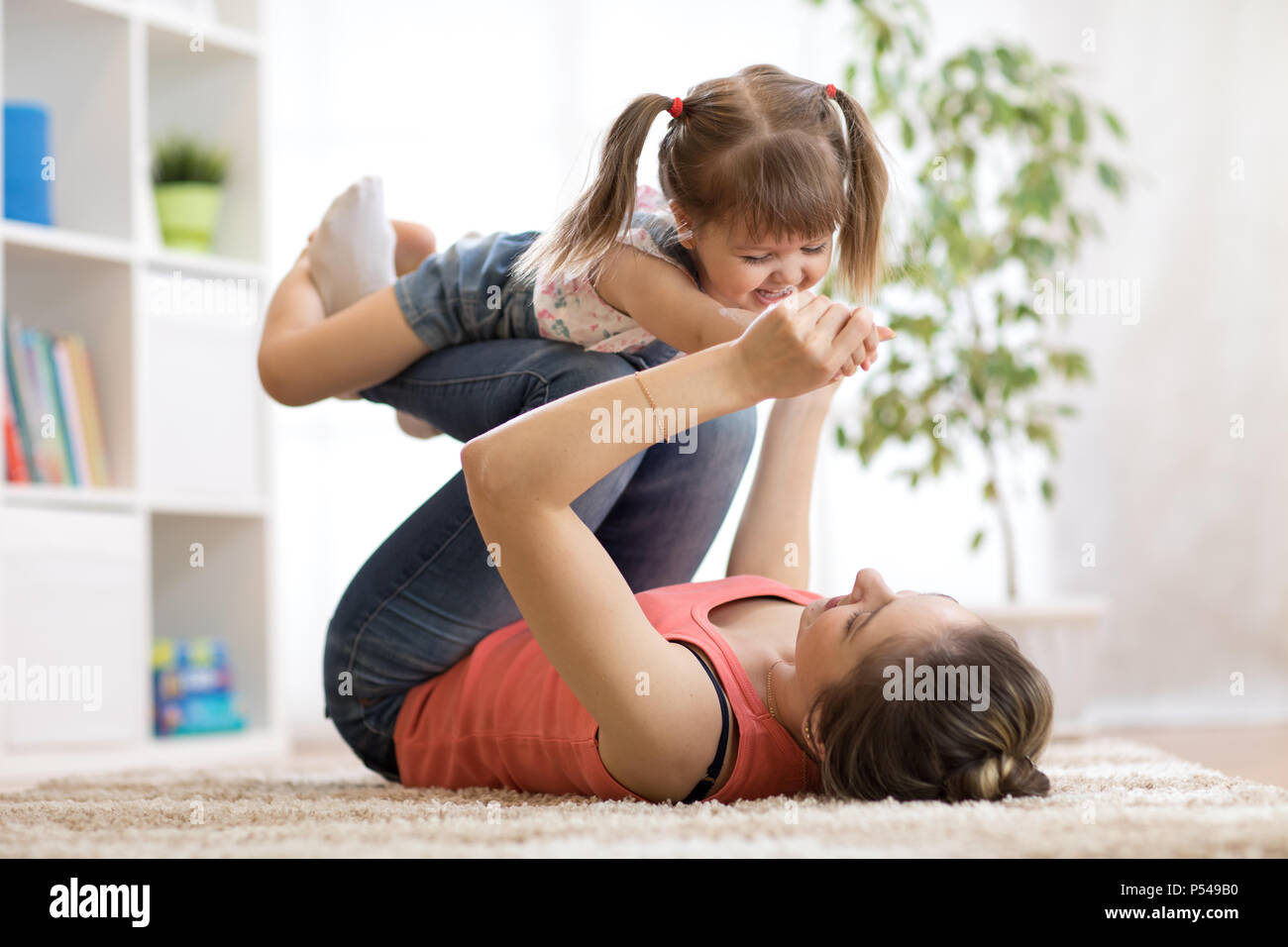 Love and family people concept - happy mom and child daughter having a fun at home Stock Photo
