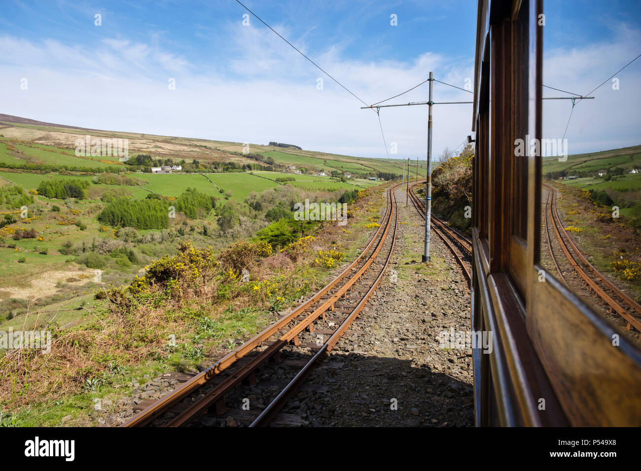 View through window from Snaefell Mountain Tramway electric railcar train descending railway tracks on Fell system track built 1895. Laxey Isle of Man Stock Photo