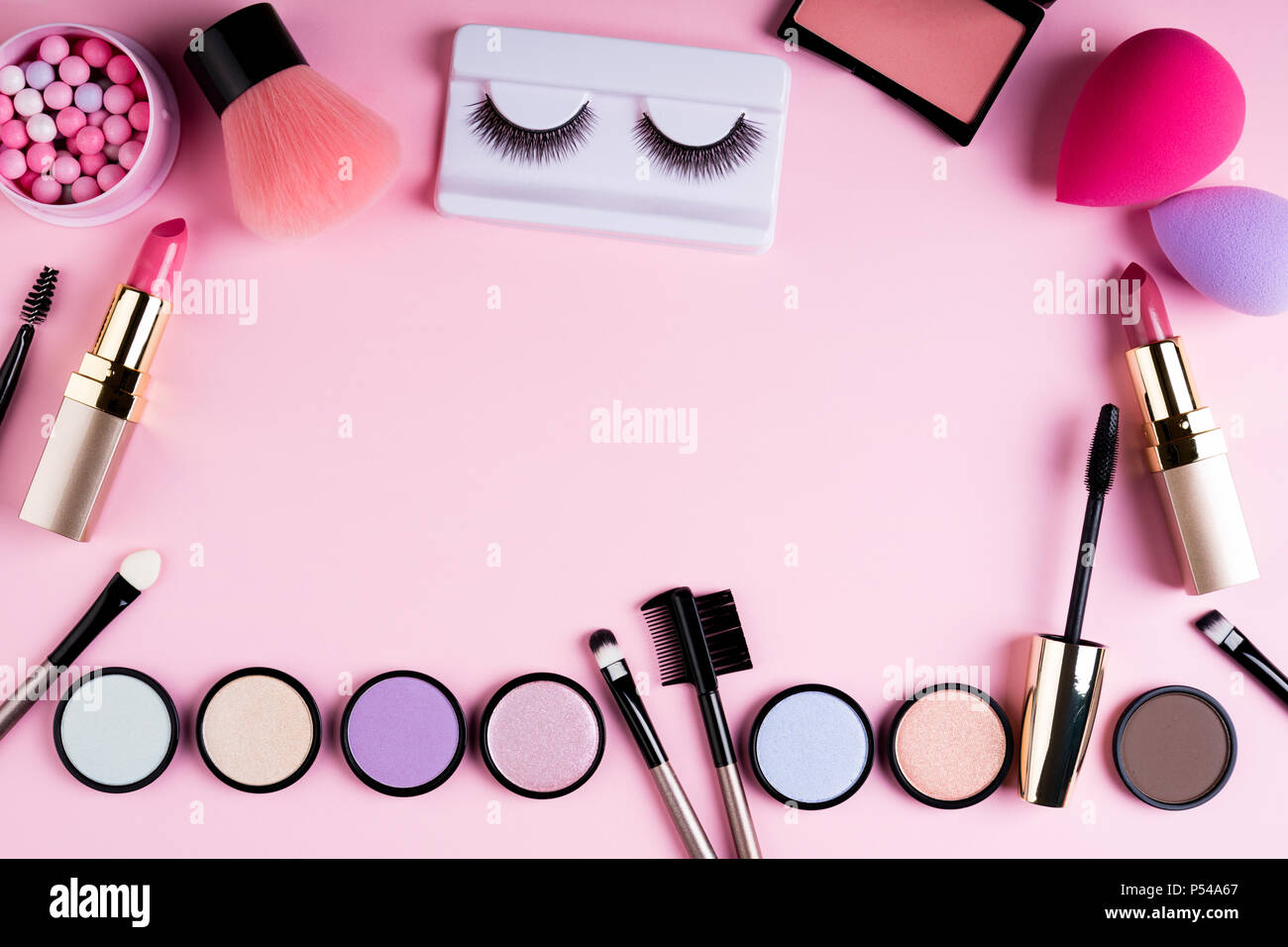 Makeup products and decorative cosmetics on pink background flat lay. Fashion and beauty blogging concept. Top view, copy space Stock Photo