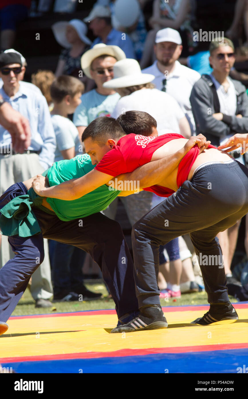 KAZAN, RUSSIA - JUNE 23, 2018: Traditional Tatar festival Sabantuy - Two young men fighting in folk wrestling kuresh outdoors Stock Photo