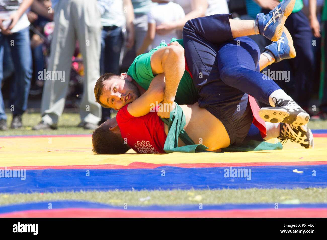 KAZAN, RUSSIA - JUNE 23, 2018: Traditional Tatar festival Sabantuy - Two male wrestlers fighting on tatami in folk kuresh battle Stock Photo