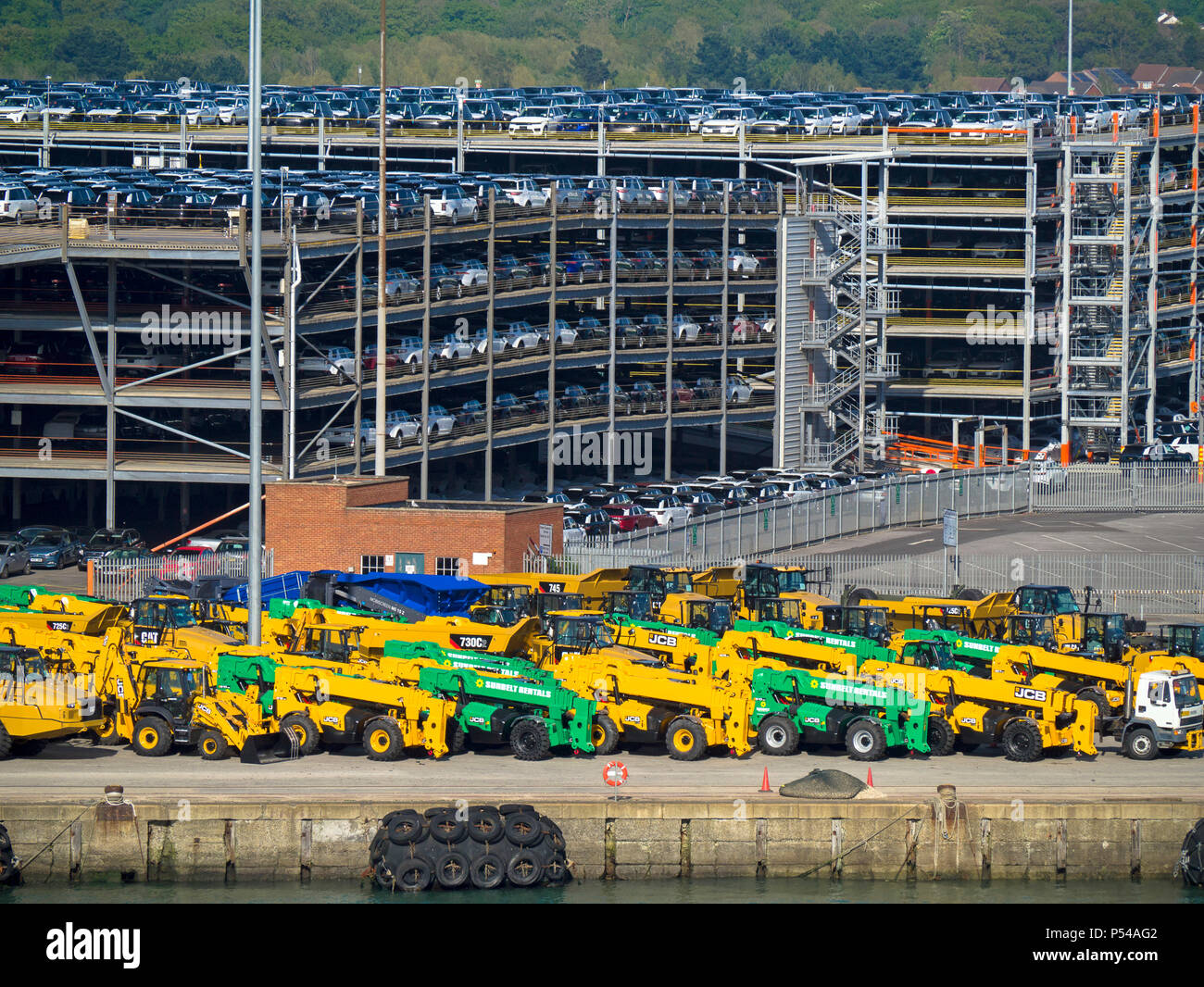 Cars and heavy plant machinery ready for export at the busy port of  Southampton docks, England Stock Photo