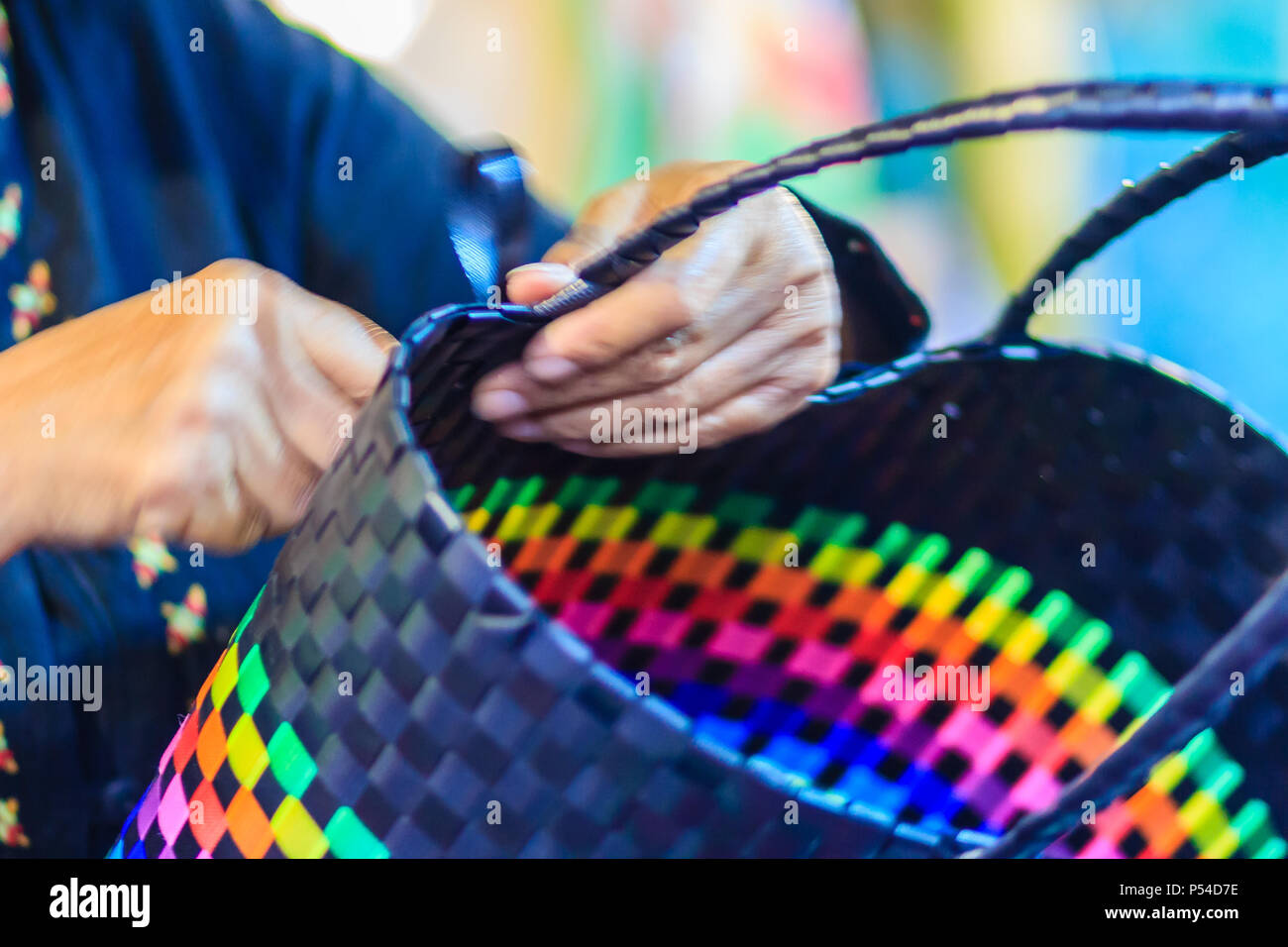 Close up hand of weaver during weaving basket made from plastic fiber. Weaver is weaving plastic