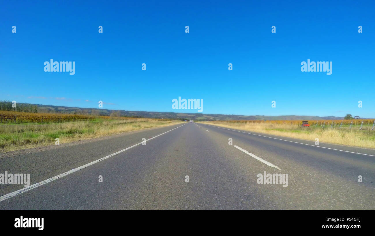 Vehicle POV, driving along wide, flat open highway through McLaren Vale South Australia. Stock Photo