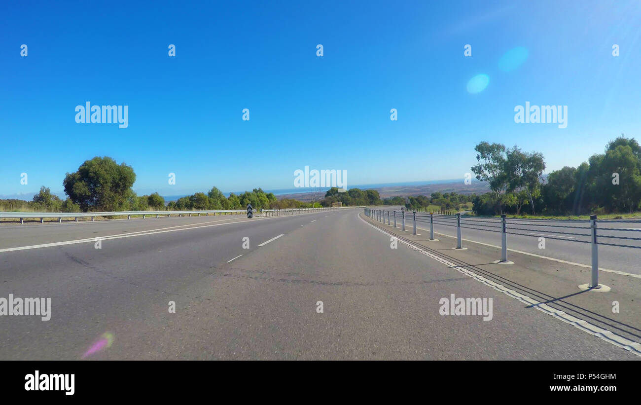 Vehicle POV, driving along wide, flat open highway through McLaren Vale South Australia with views of Willunga in distance. Stock Photo