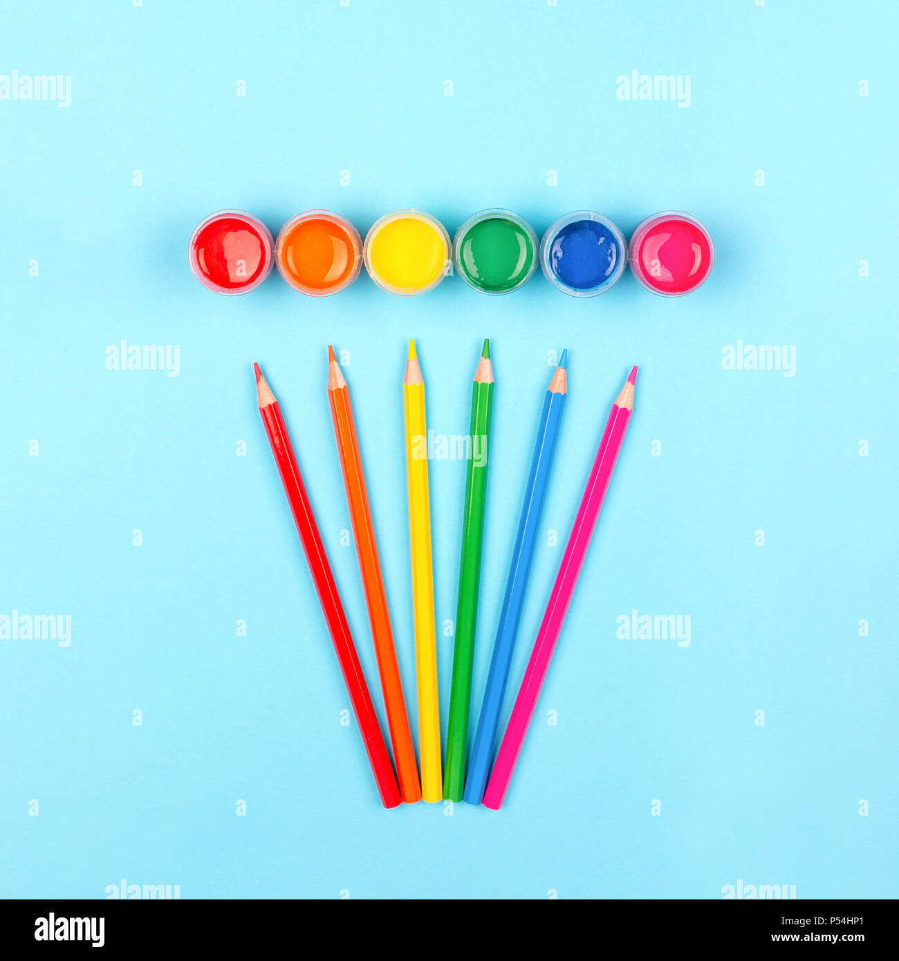 Colorful paints and pencils on wooden background. Stock Photo
