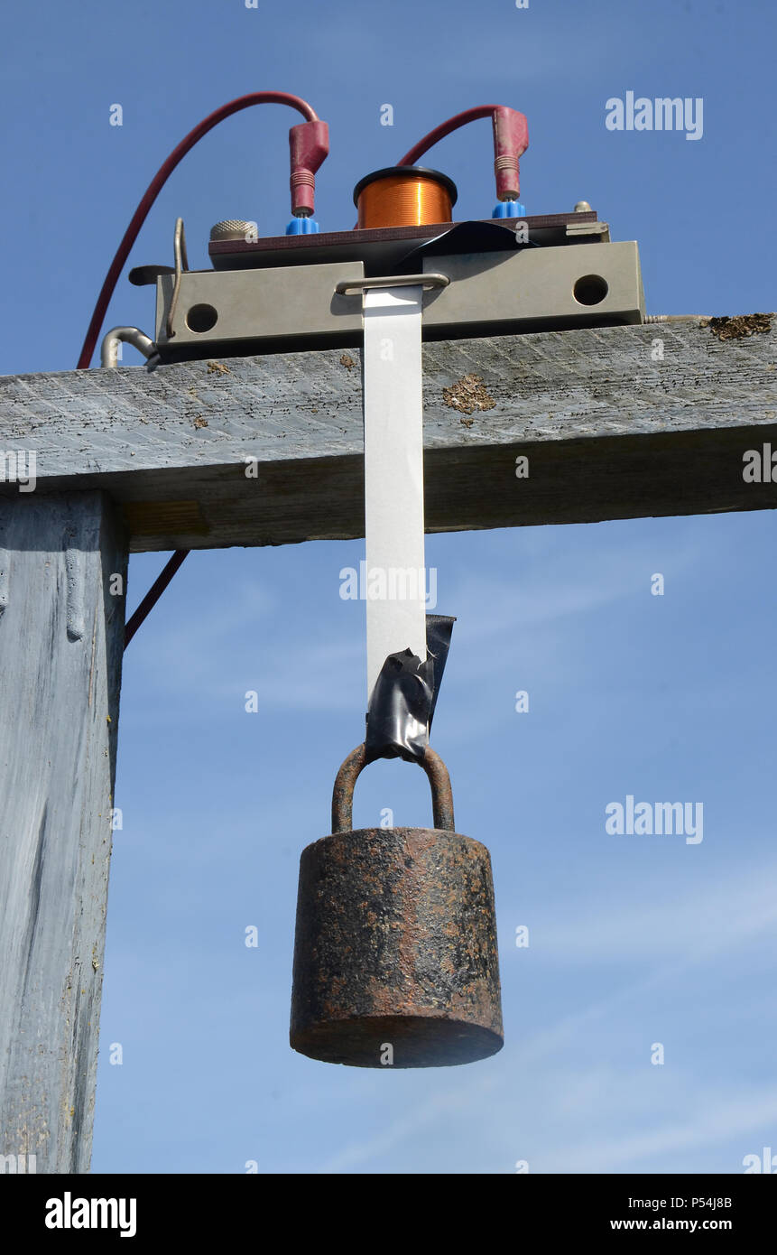 A Motion timer with a paper strip is ready to measure free fall of a weight. Stock Photo