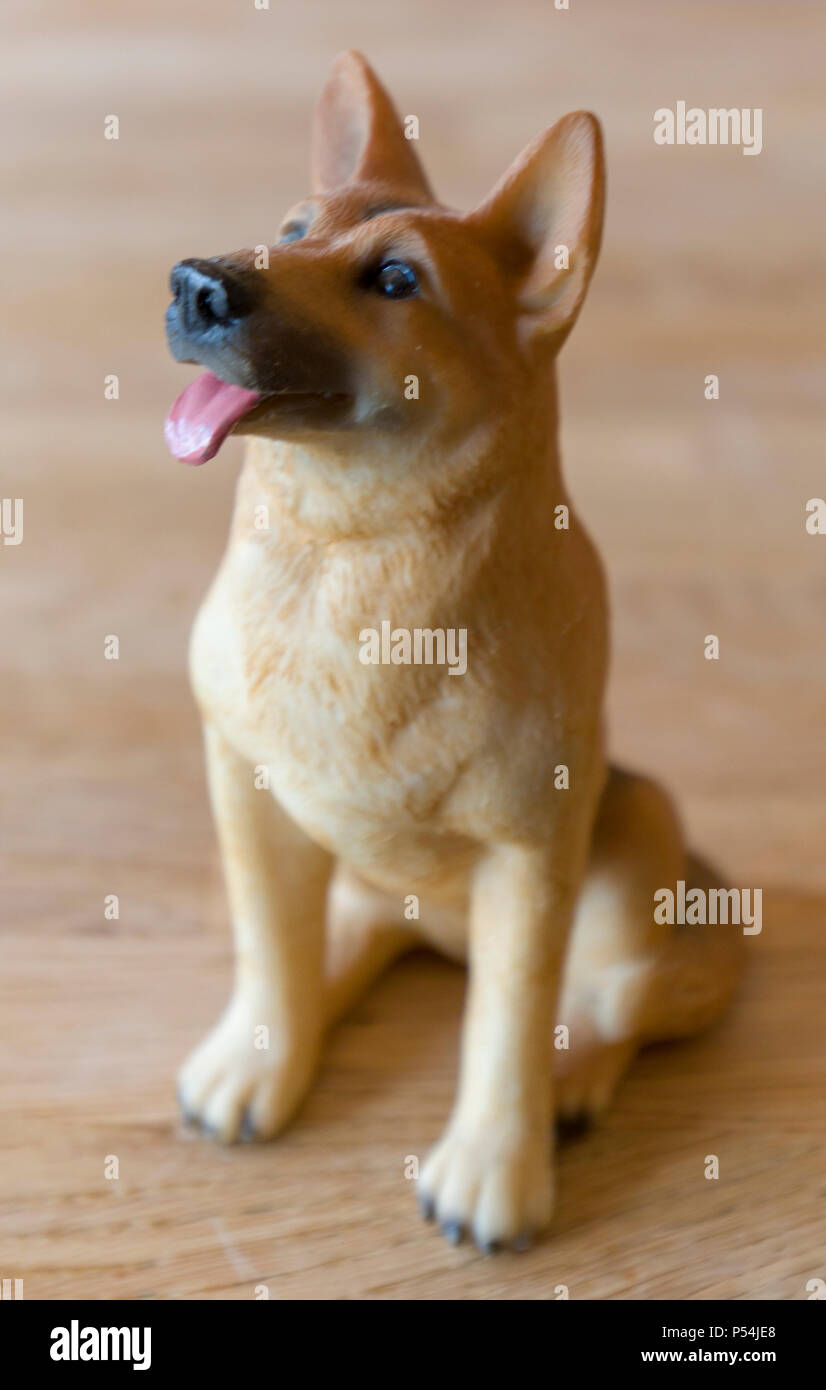 German Shepard figurine on a wooden background Stock Photo