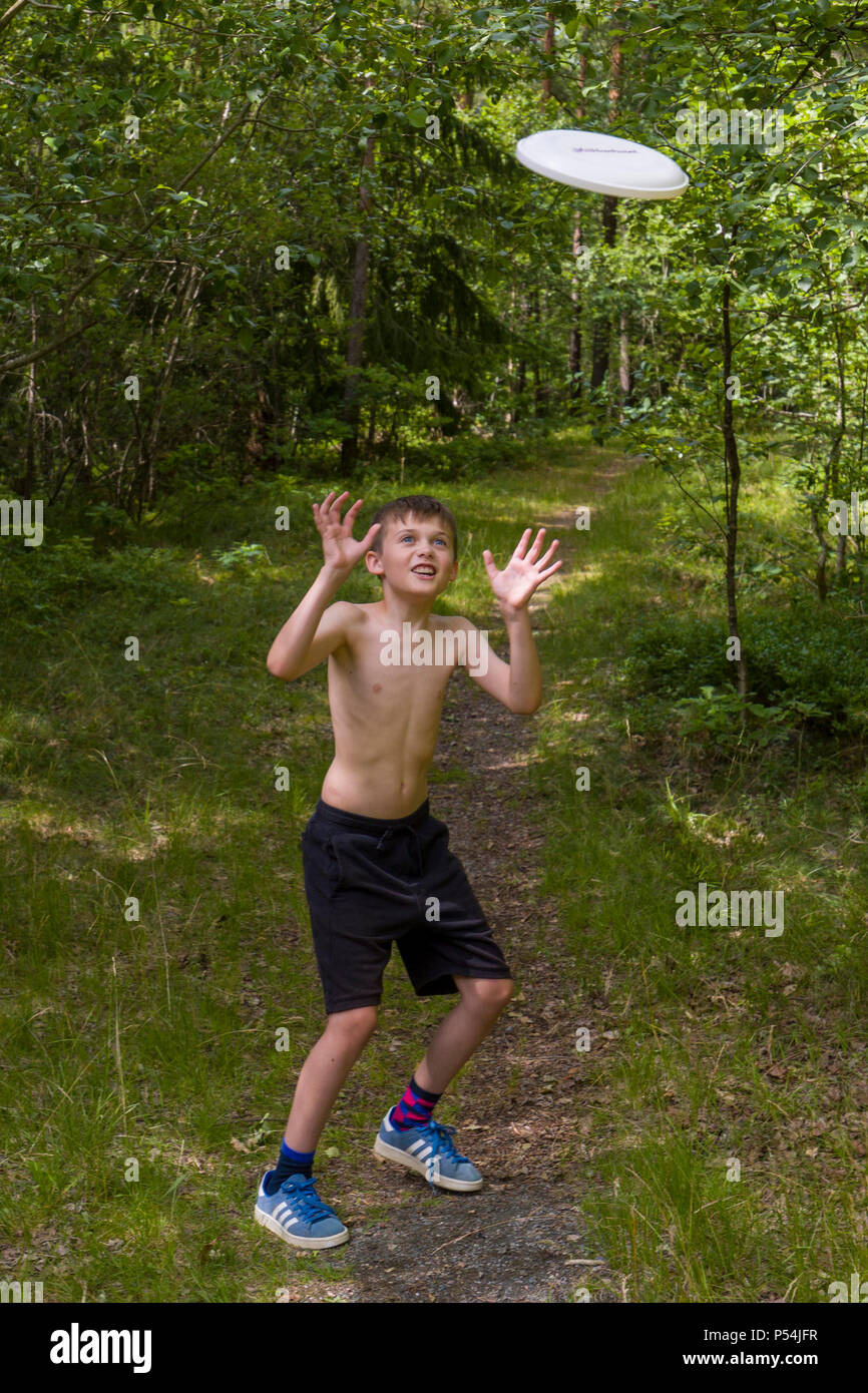Shirtless caucasian young boy having fun throwing and catching a