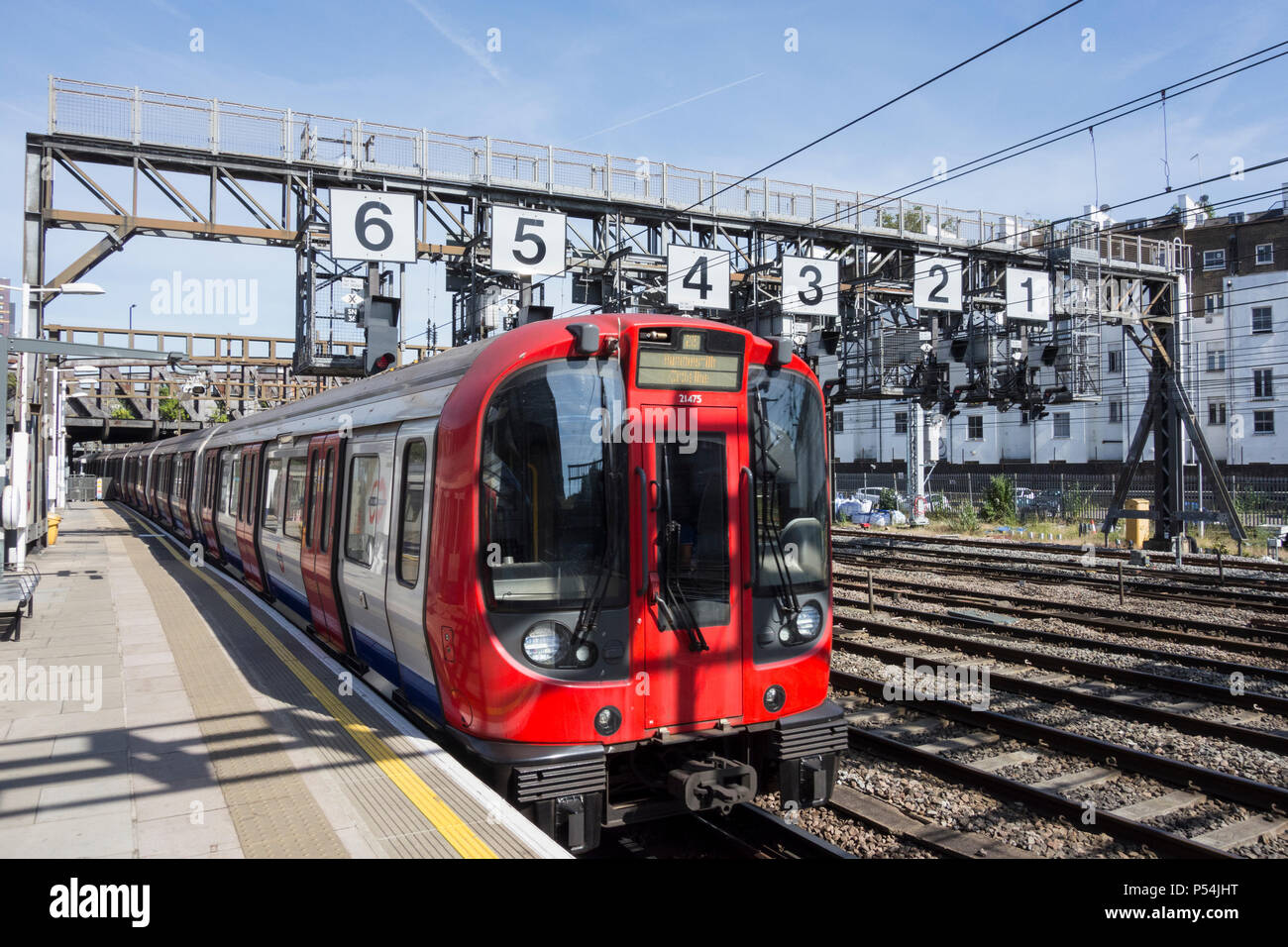 A Hammersmith and City Line Circle Line train passing under the Royal Oak signaling gantry on
