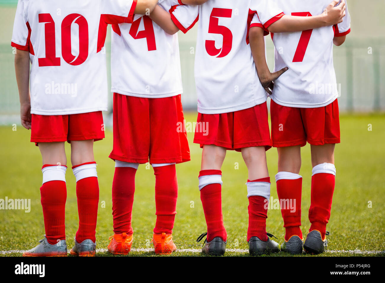 Football children team. Kids soccer substitute players standing together on a row. Football sports tournament for young boys. Four kids watching footb Stock Photo