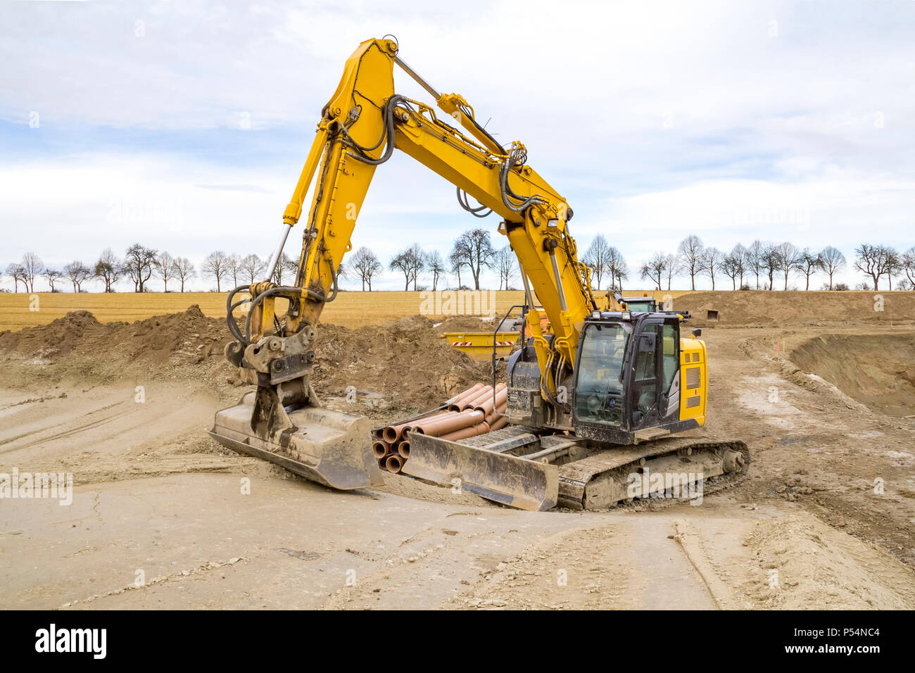yellow excavator at a loamy construction site Stock Photo - Alamy