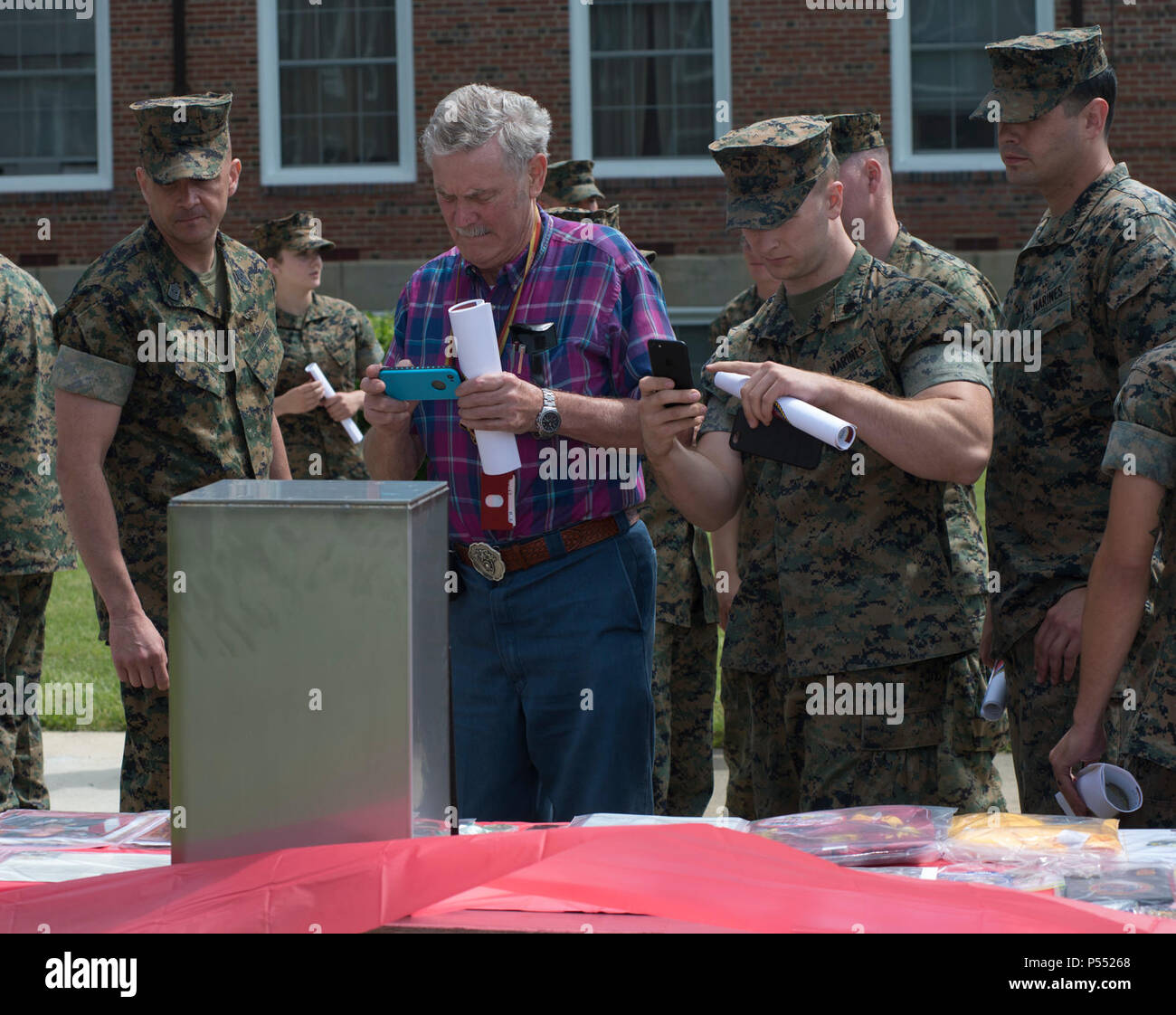 Attendees of the Centennial Celebration Ceremony look at the items that will be placed in a time capsule later this year, at Lejeune Field, Marine Corps Base Quantico (MCBQ), Va., May 10, 2017. The event commemorates the founding of MCBQ in 1917, and consisted of performances by the U.S. Marine Corps Silent Drill Platoon and the U.S. Marine Drum & Bugle Corps. Stock Photo