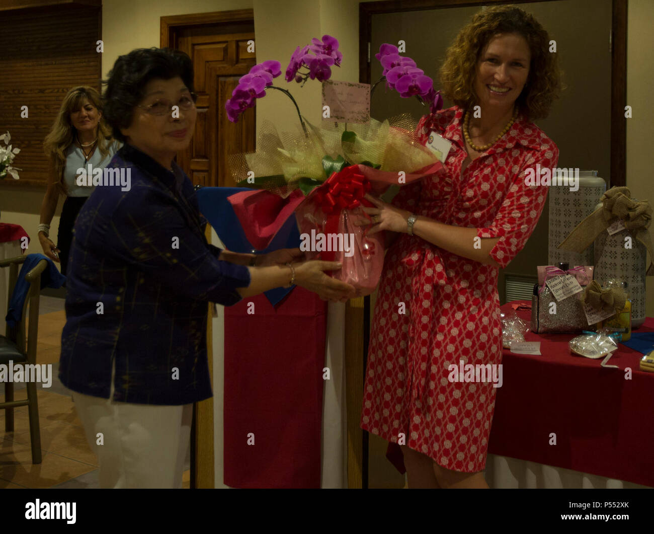 Kimiyo Taira, left,  gives a gift to Marlow Townes during the American Women’s Welfare Association’s Annual Friendship Social May 10 at Torii Station, Okinawa, Japan. Taira is of an organization for a single parent program in Okinawa. Townes is the president of the AWWA and has been volunteering since 2014. Stock Photo